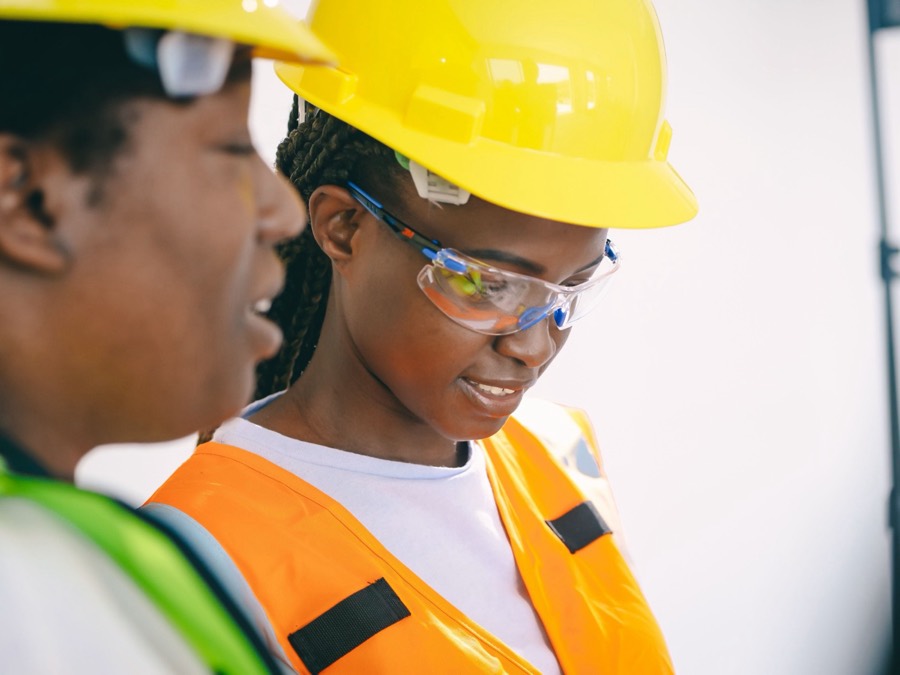 Two colleagues in hard hats reviewing work